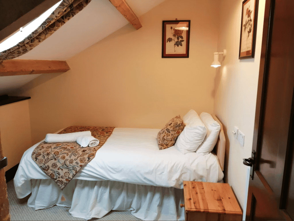 Cozy attic bedroom with wooden beams and floral decor
