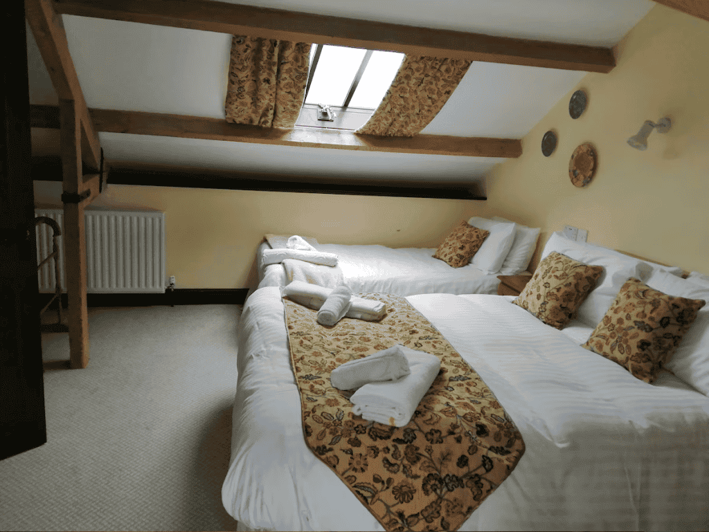Cozy attic bedroom with exposed beams and twin beds