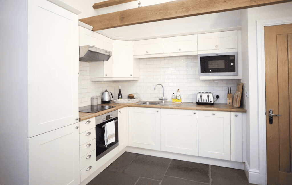 Modern kitchen with white cabinets and wooden accents
