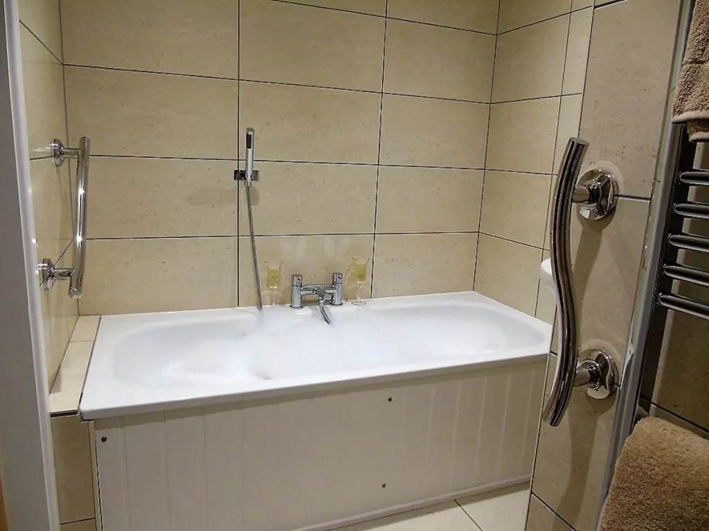 Modern bathroom with white bathtub and tiled walls