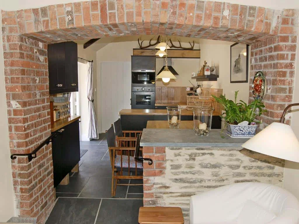 Rustic kitchen interior with brick arch and modern appliances