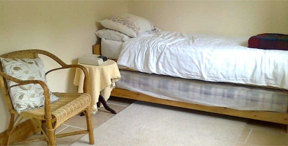 Cozy bedroom with wooden bed and wicker chair