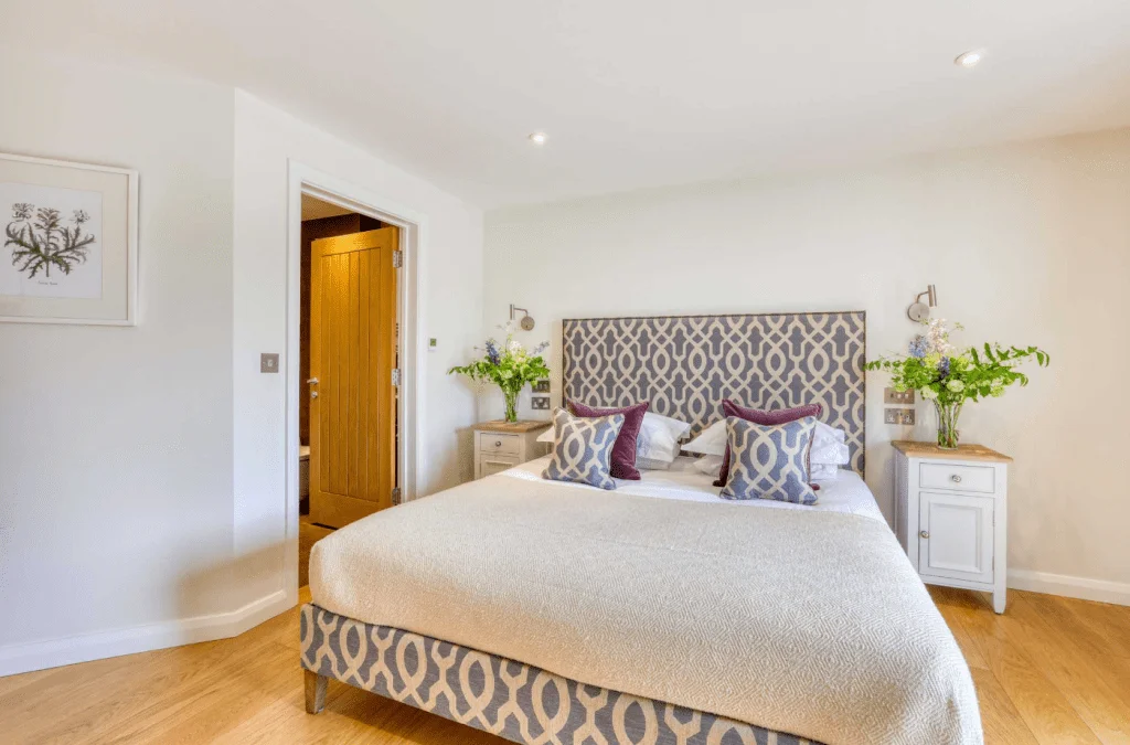 Bright modern bedroom with patterned headboard and flowers