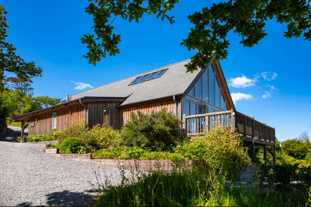 Wooden countryside house with lush garden on sunny day