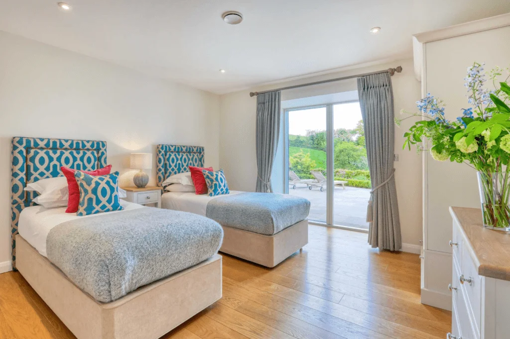Bright bedroom with two beds and garden view