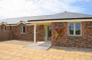 Stone cottage with flower basket and paved entrance