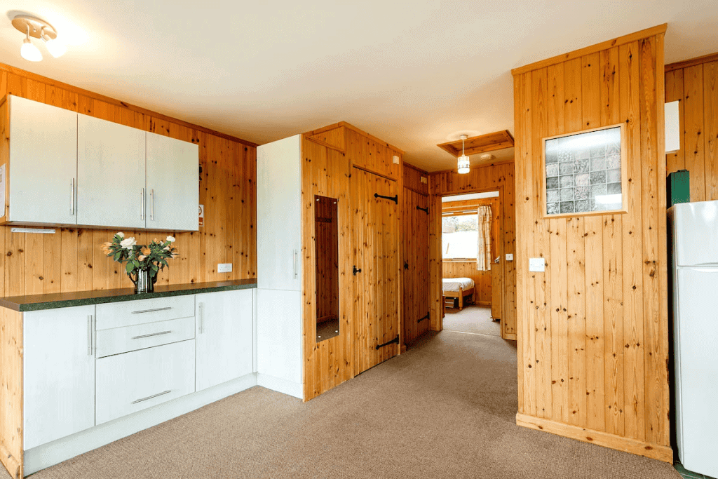 Cozy wooden cabin interior with kitchen and hallway