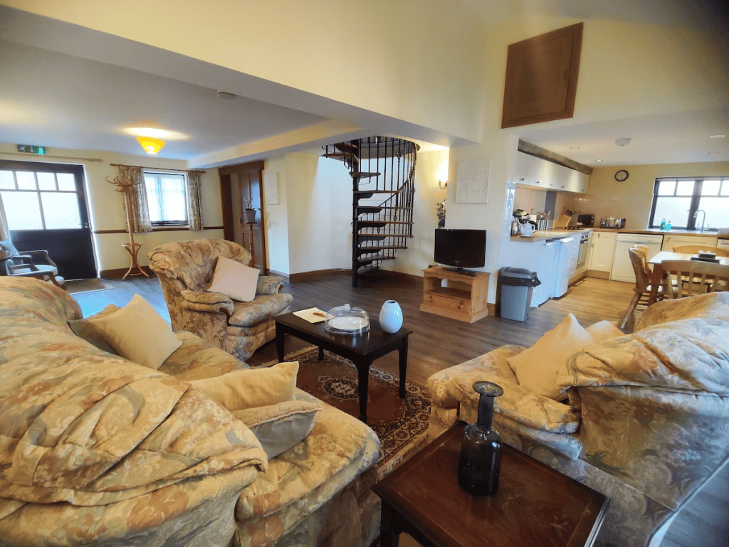 Cozy living room with spiral staircase and kitchenette
