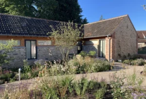 Picturesque stone cottage with lush garden in sunlight