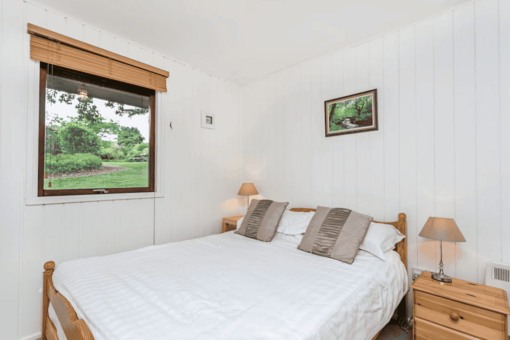 Cozy bedroom with window view of lush garden