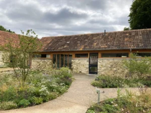 Rustic stone building with garden and cloudy sky