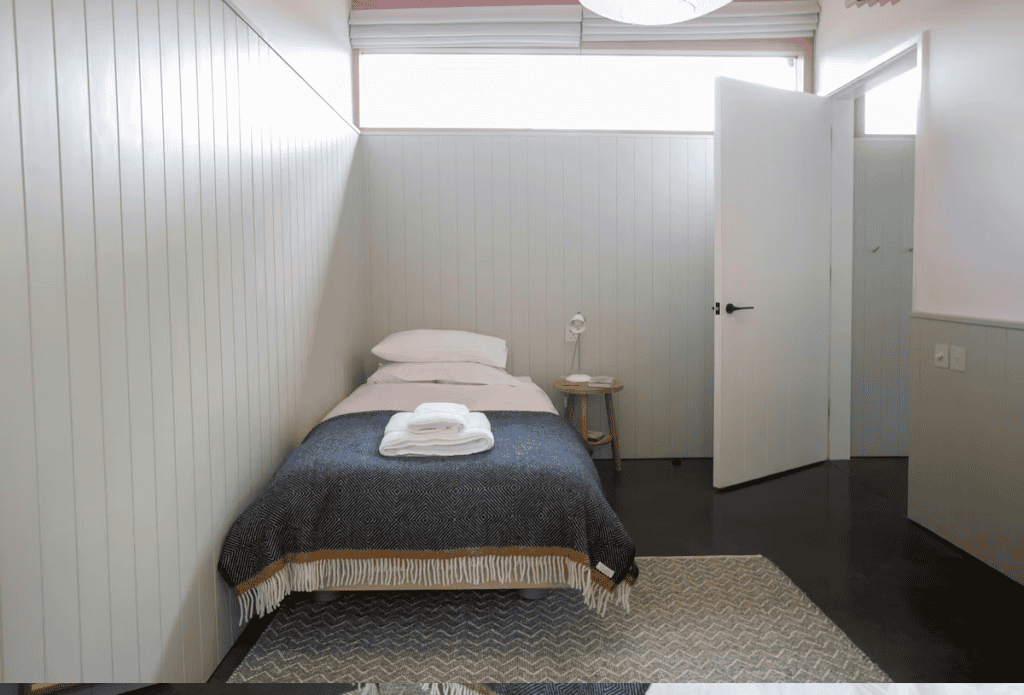 Minimalist bedroom with single bed and open door
