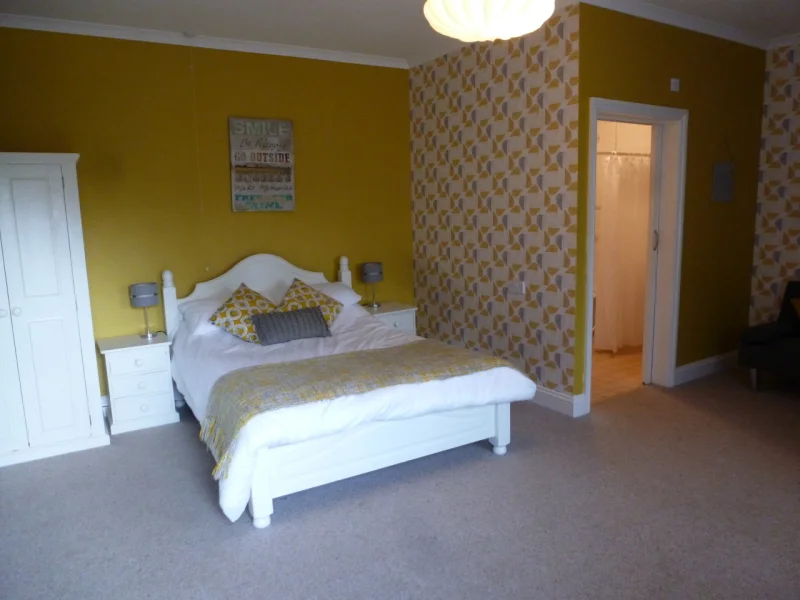 Bright yellow themed bedroom with patterned wallpaper