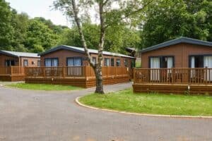 Wooden cabins with decks in lush green park