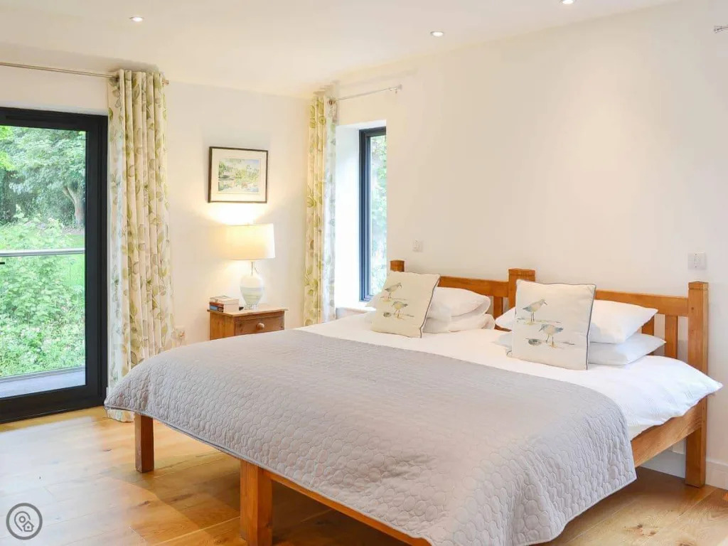 Bright bedroom with large bed and forest view window
