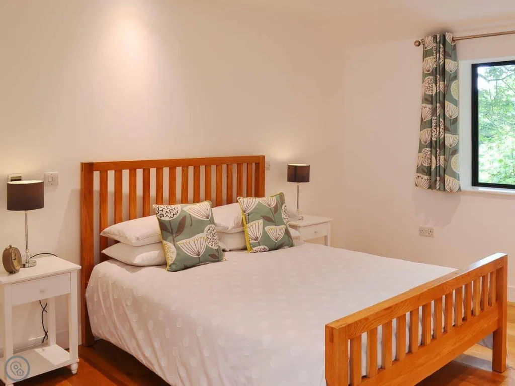 Minimalist bedroom with wooden bed and patterned cushions