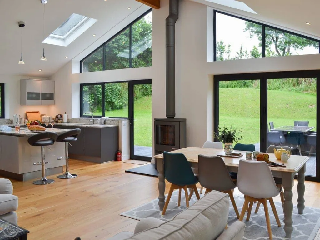 Modern kitchen and dining area with large windows and garden view