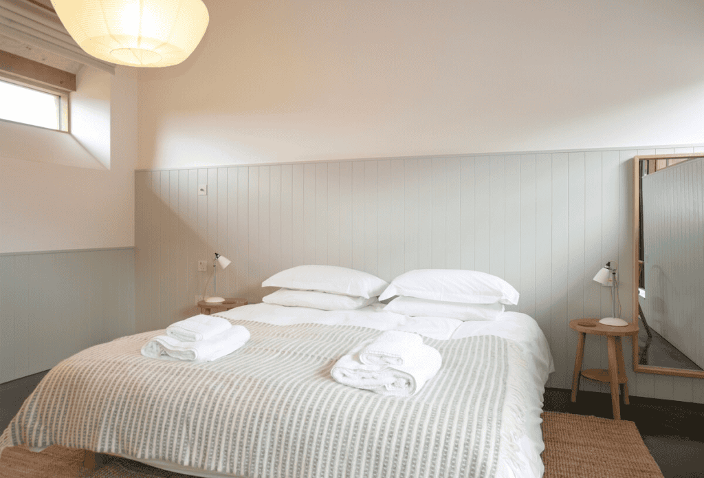 Minimalist bedroom with white bedding and wooden accents