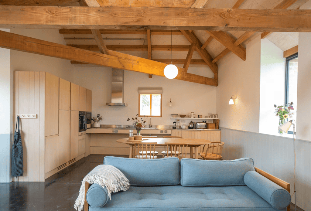 Modern kitchen with wooden beams and cozy blue sofa