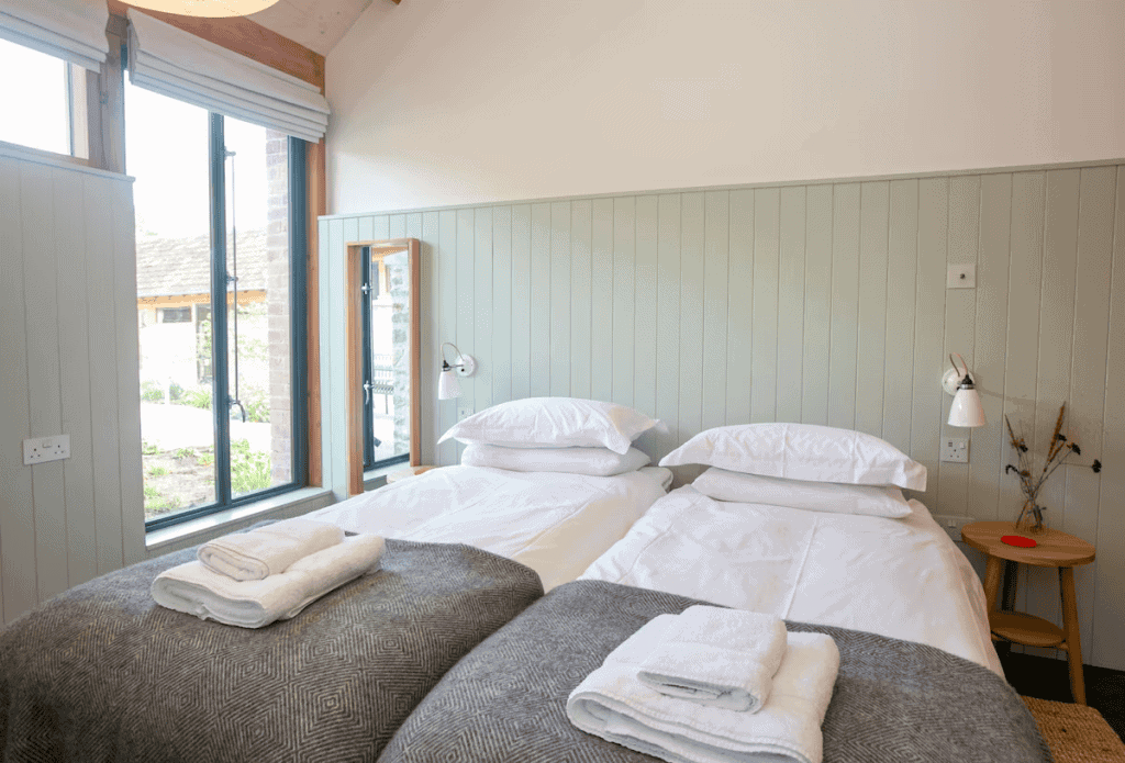 Bright modern twin bedroom with large window and decor