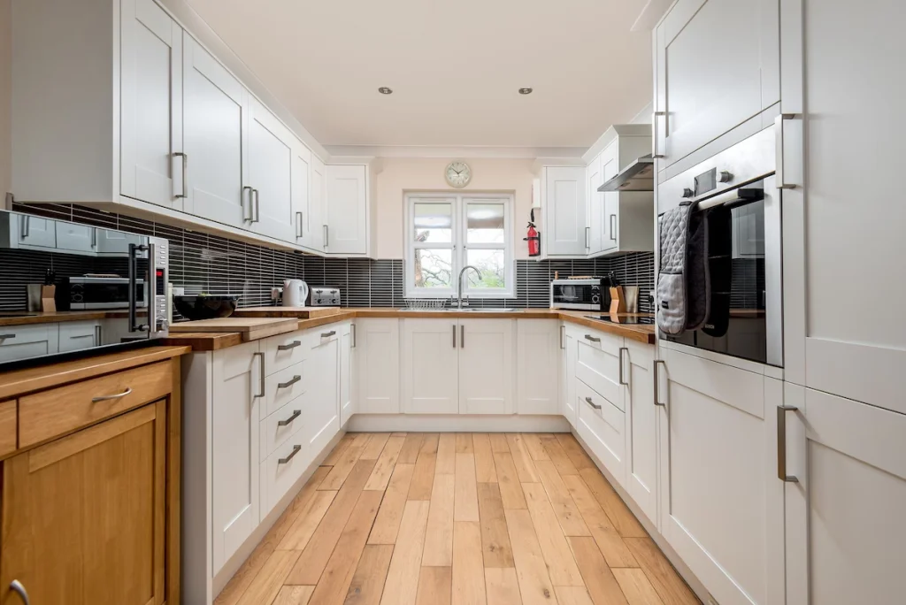 Modern kitchen with white cabinets and wooden floor
