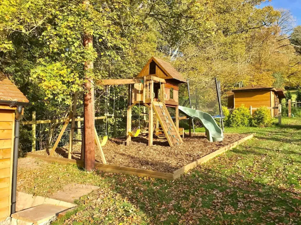 Wooden playground with slide in sunny autumn park