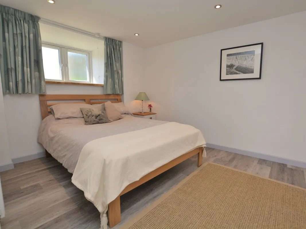Minimalist bedroom with wooden bed and beige linens
