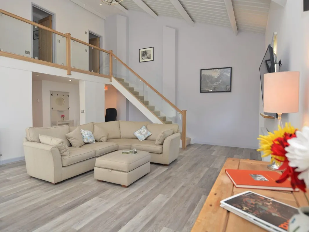 Spacious living room with sofa and wooden staircase