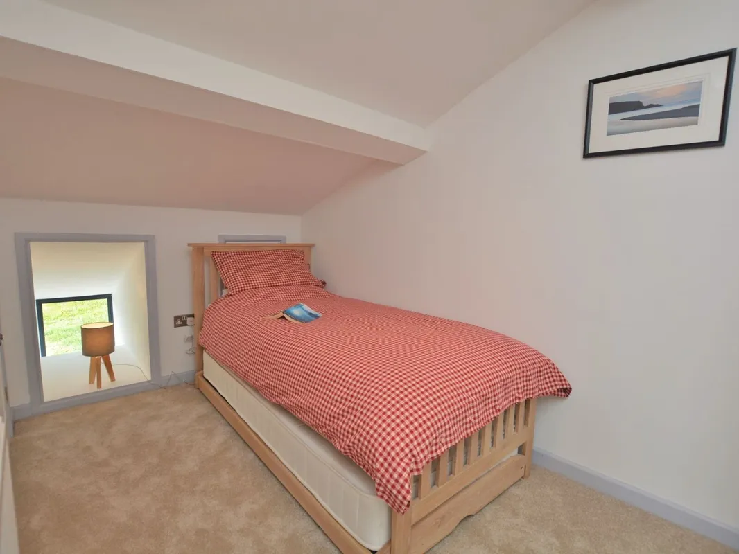 Cozy bedroom with red checkered bedding and framed art
