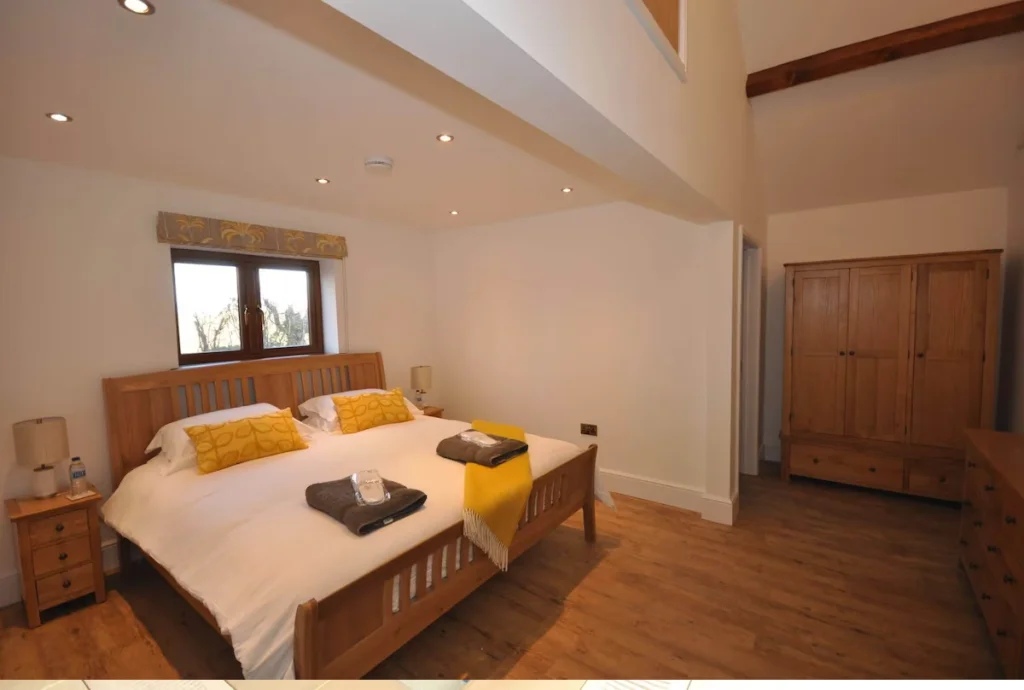 Spacious bedroom with double bed and wooden furniture
