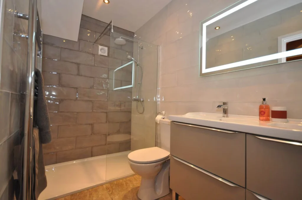 Modern bathroom with shower and illuminated mirror
