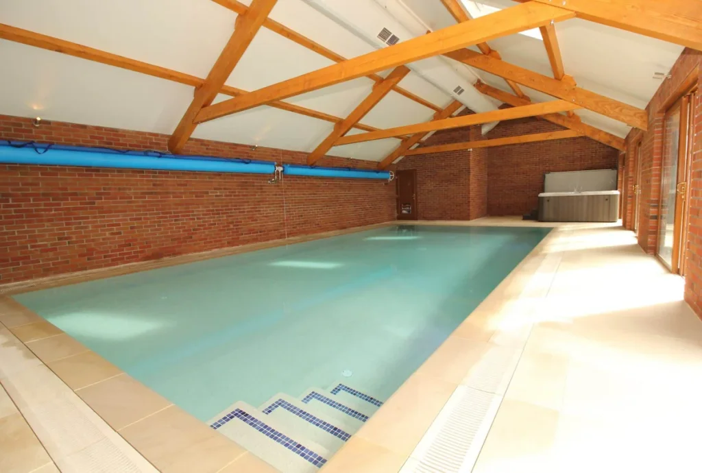 Indoor swimming pool with wooden beams and brick walls