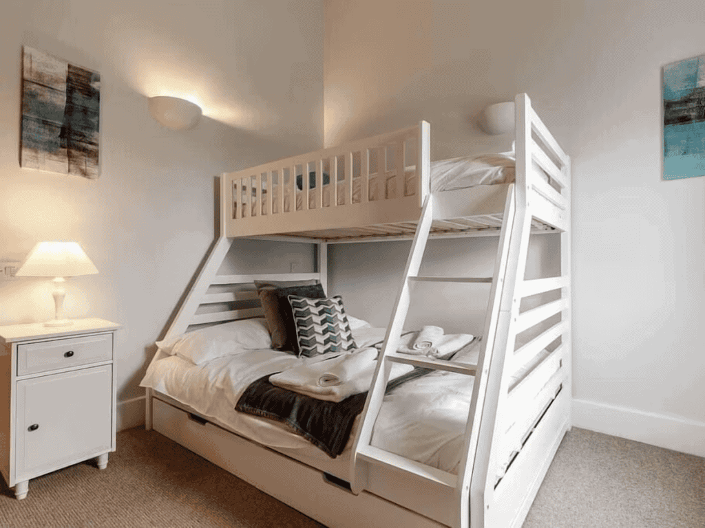 Cozy bedroom with white wooden bunk beds and decor
