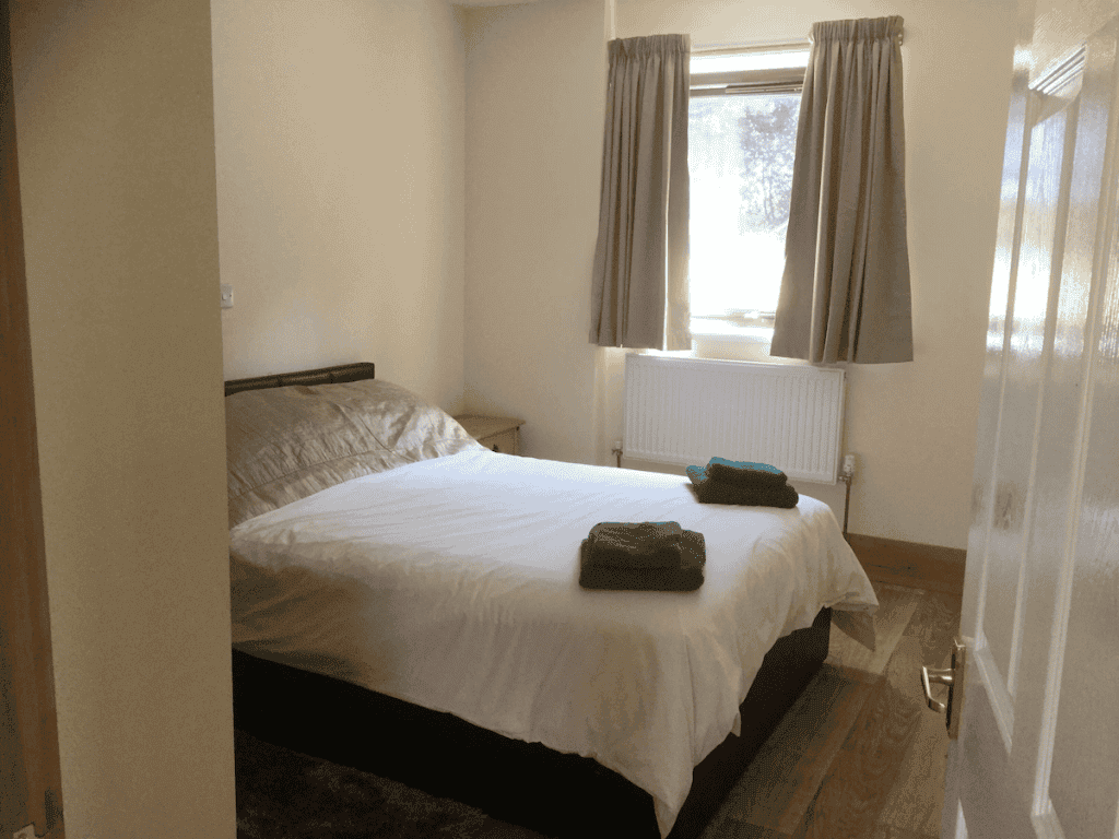 Cozy minimalist bedroom with bright window and double bed