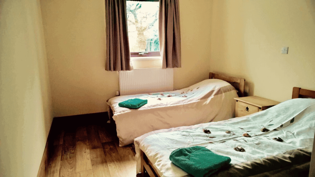 Cozy twin bedroom with window view and wooden floor