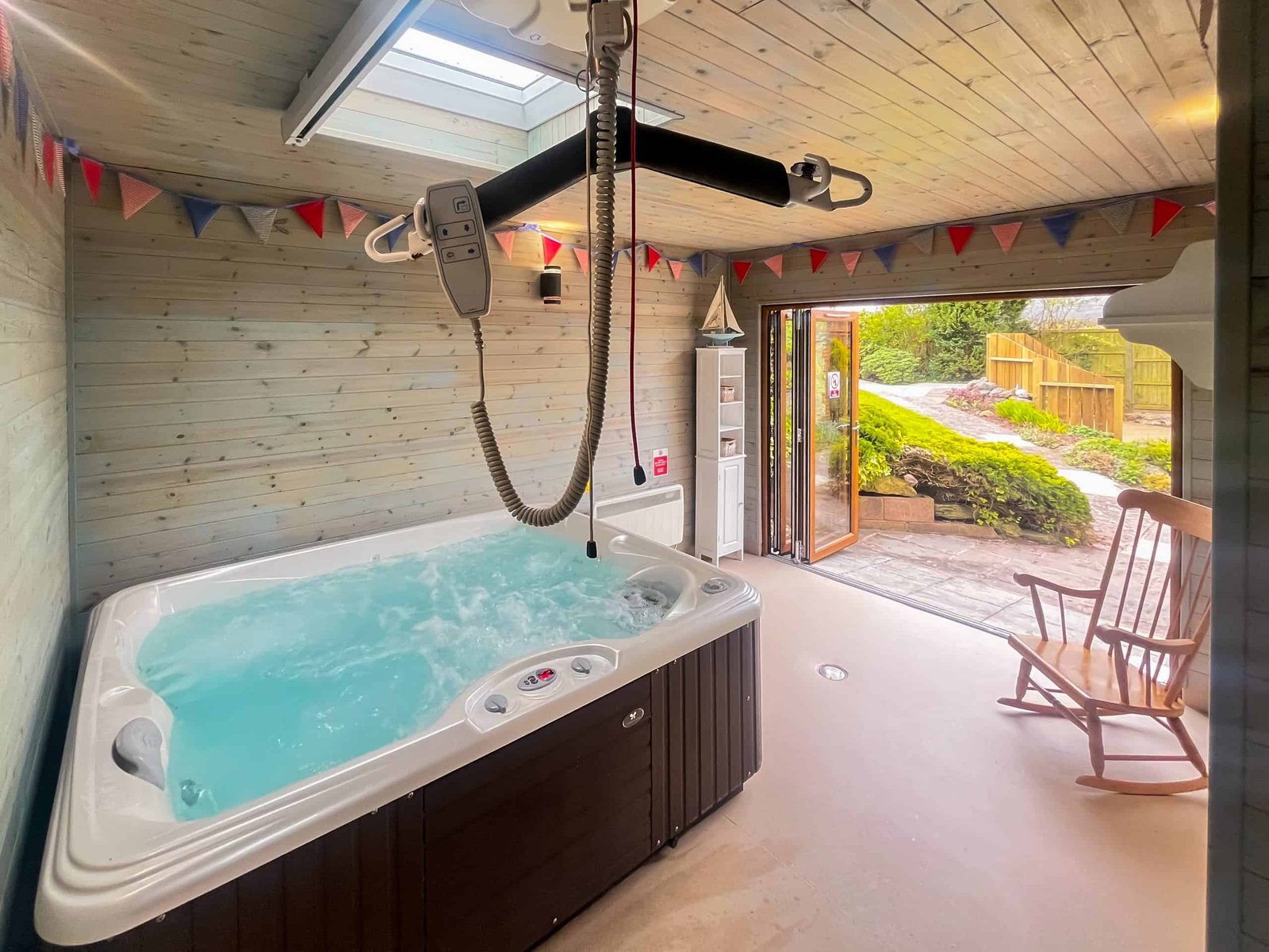 Indoor jacuzzi with bunting and open garden view