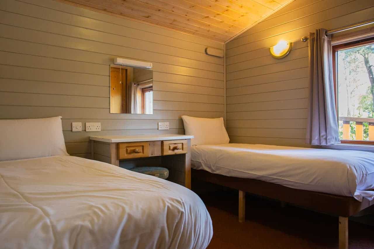 Cozy twin bedroom with wooden interior and natural light
