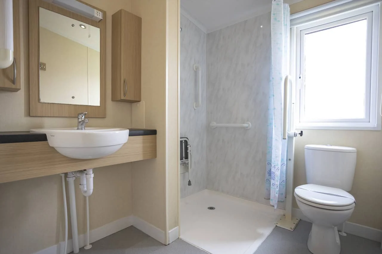 Modern accessible bathroom with shower, toilet, and sink