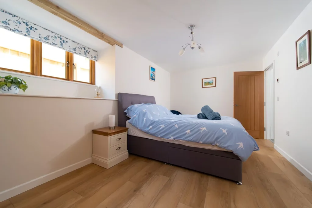 Cozy bedroom with wooden floor and blue bedding