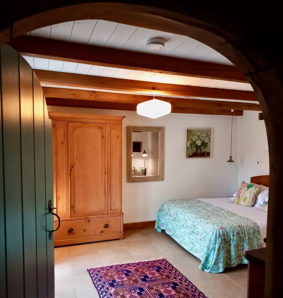 Cozy bedroom with wooden furniture and curved doorway