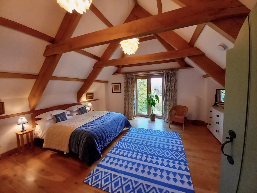 Cozy attic bedroom with exposed beams and blue accents