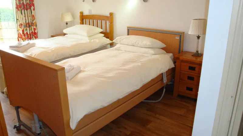 Bright cozy bedroom with twin beds and wooden furniture