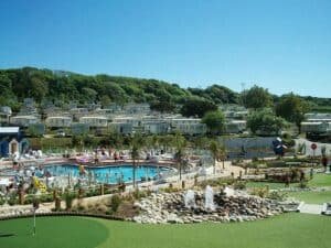 Sunny holiday park with pool, mini-golf, and caravans