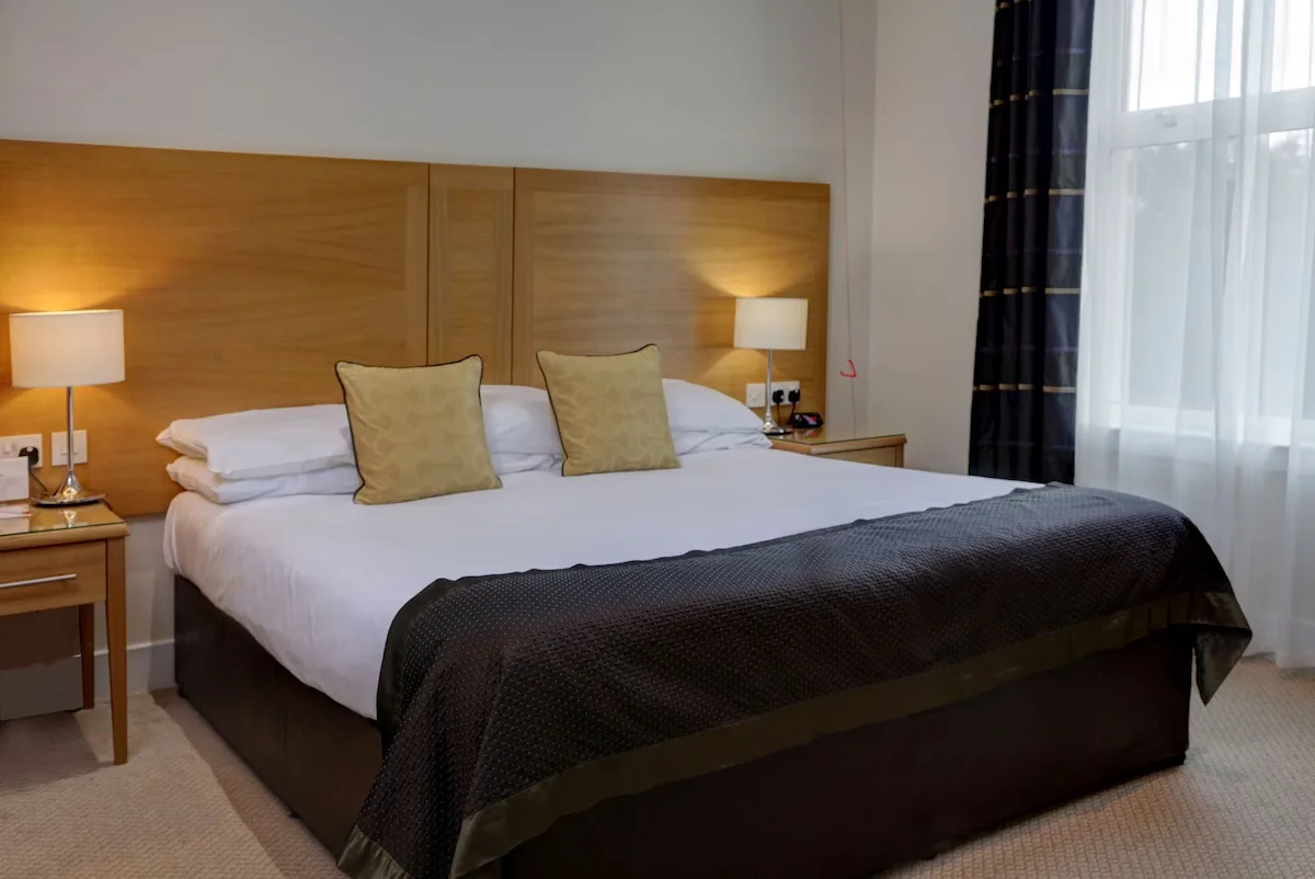 Modern hotel bedroom with neat, inviting double bed