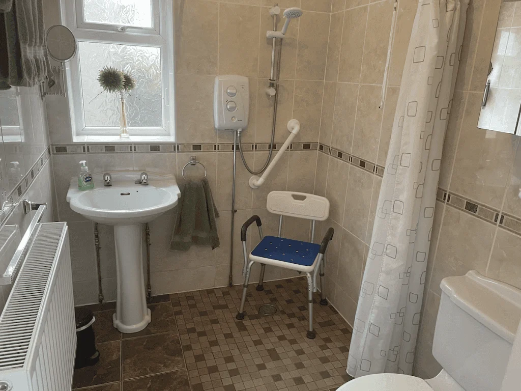 Accessible bathroom with shower chair and safety handles