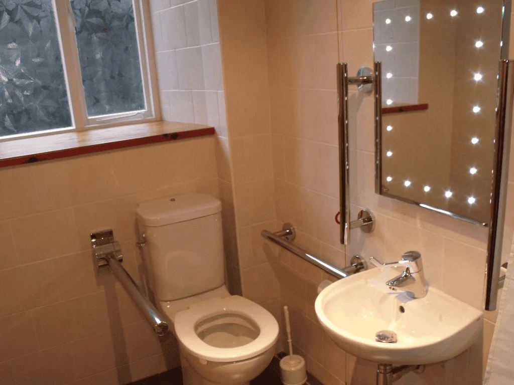 Modern bathroom with illuminated mirror and tiled walls