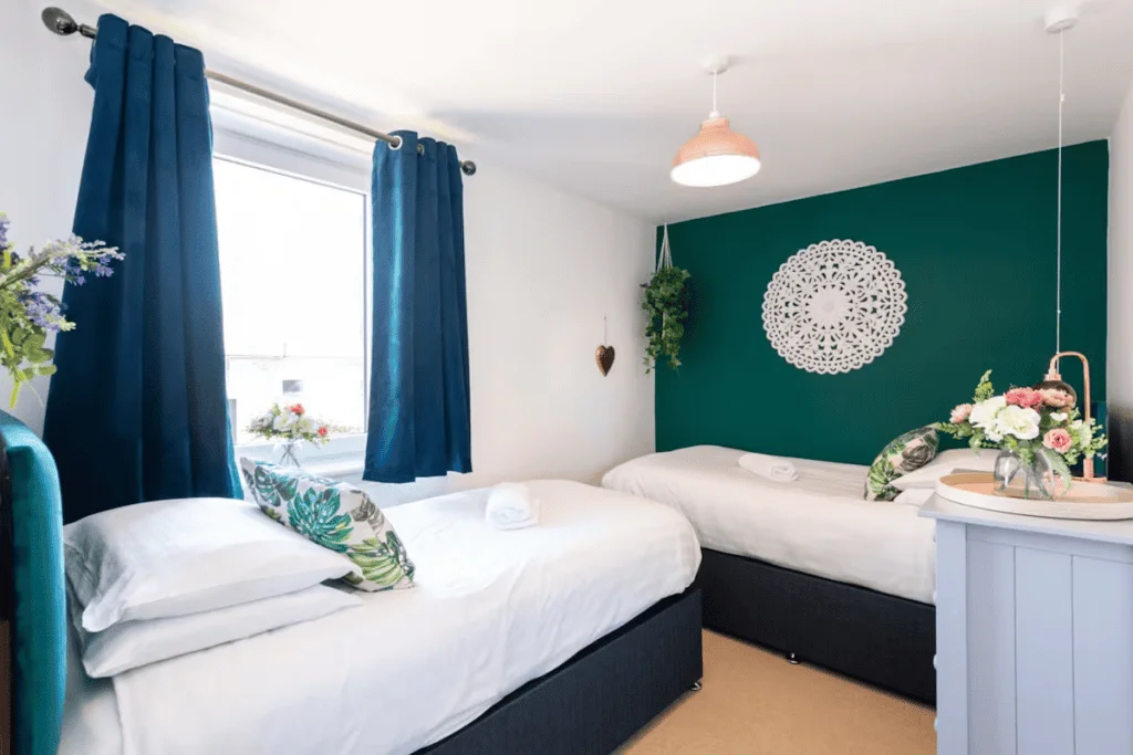 Elegant twin bedroom with vibrant teal accents and decor