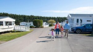 Family walking in sunny caravan park