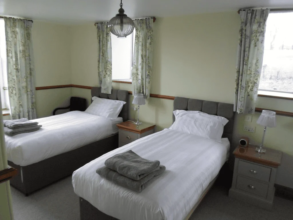 Twin bedroom with white bedding and floral curtains