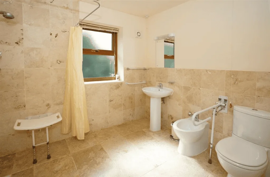 Accessible bathroom with support rails and shower curtain